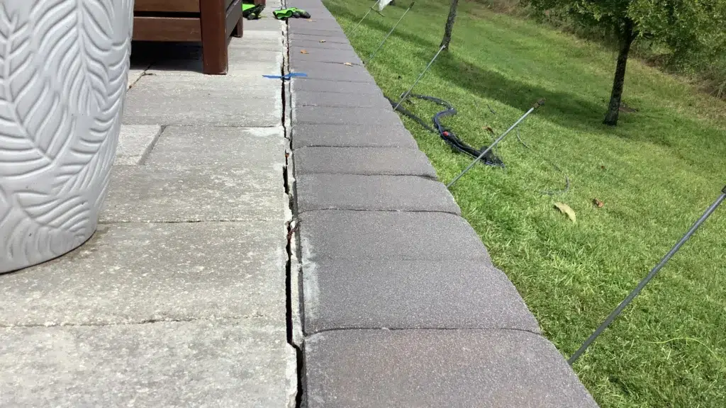 Cracks along concrete retaining wall cap prior to repair, documented by Helicon as part of residential foundation assessment