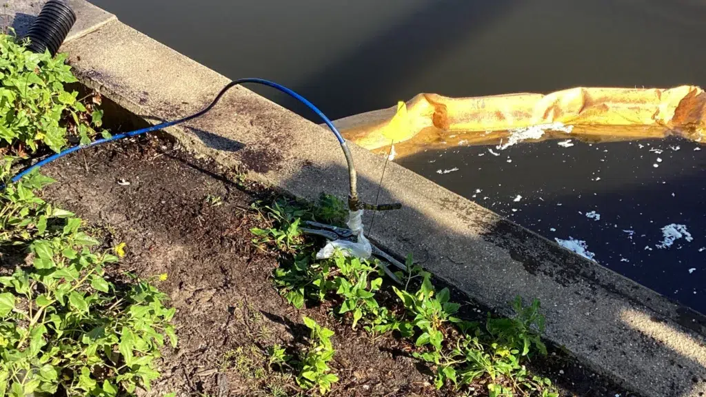 Helicon technicians injecting structural grout into a residential seawall void using high‑pressure hoses to stabilize eroded soil along the waterfront.